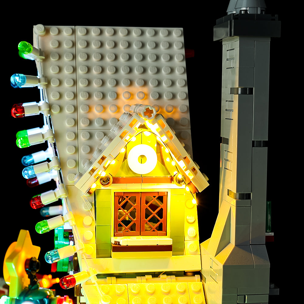 Warm light along the snowy side gable beside the tall grey chimney of LEGO Elf Club House 10275