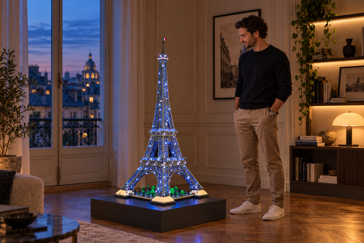 LEGO® Eiffel Tower 10307 with Game of Bricks Standard lighting in a softly lit room beside a person.
