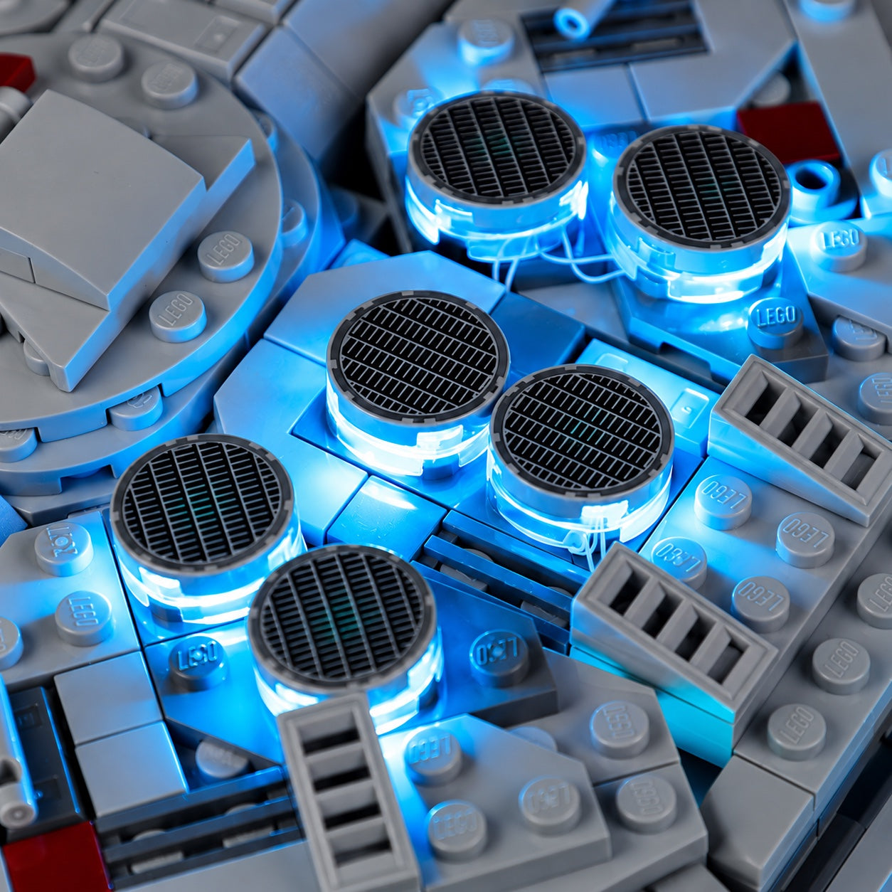 Six circular grilles on the Millennium Falcon upper hull lit in blue
