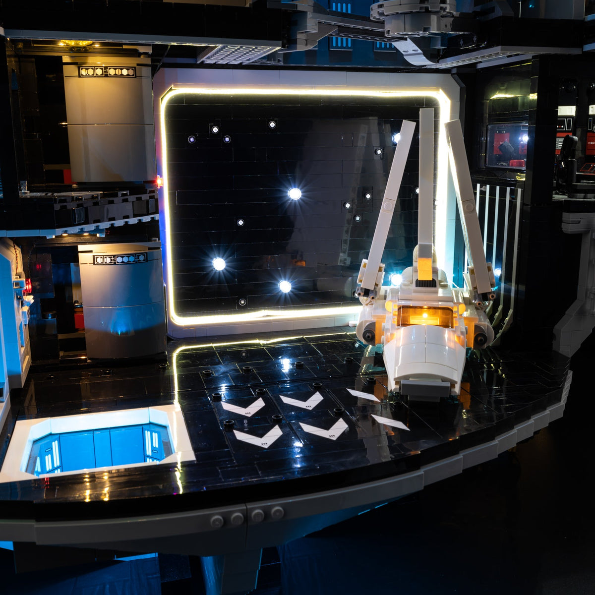 The Imperial Shuttle in the illuminated hangar, framed by a warm white border and small lights