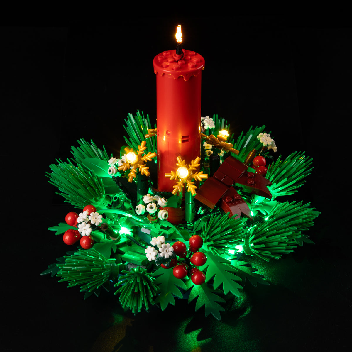 Real alternate view of the Game of Bricks lighting among the red candle, white blossoms and greenery of LEGO® Christmas Table Decoration 40743.