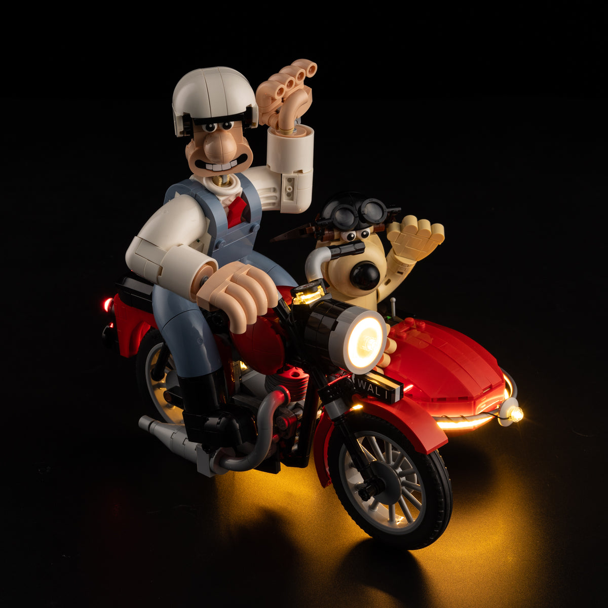Real product photo of the brick-built Wallace and Gromit waving on their illuminated motorbike and sidecar.
