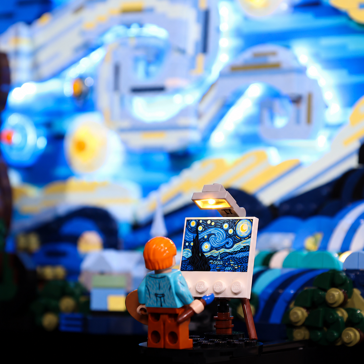 Painter minifigure and easel beside a warm lamp